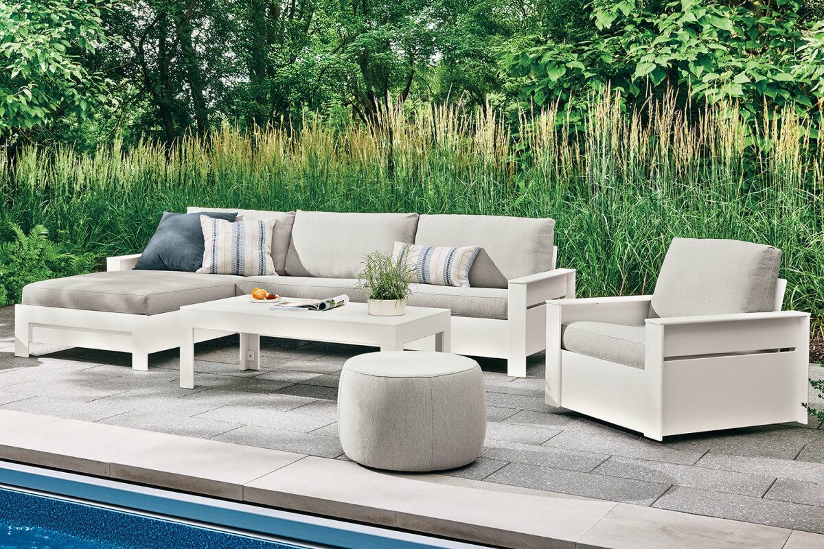Rayo collection with cushioned seating, chaise lounge, ottoman, and Henry table on a poolside patio.