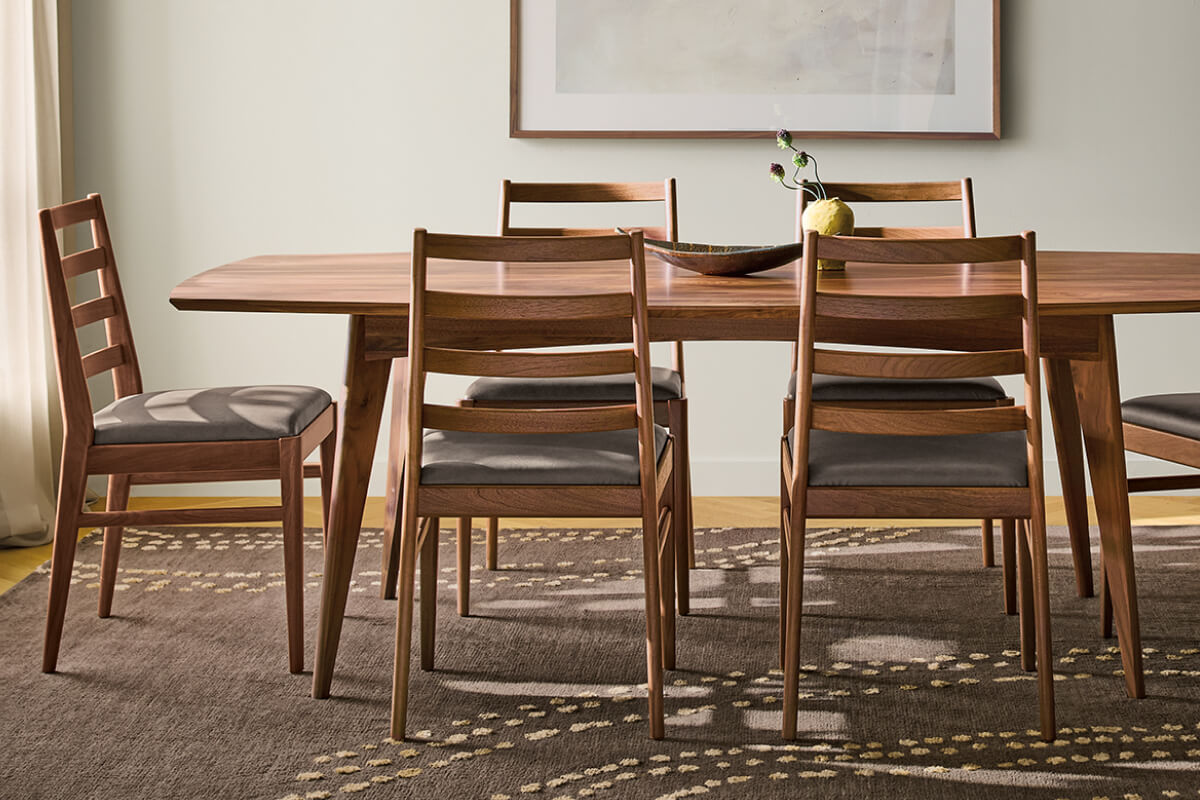 Ventura dining table in walnut paired with six Conway dining chairs featuring upholstered seats and ladder backs.