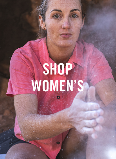 Woman wearing a pink Desert Pucker clapping hands with climbing chalk