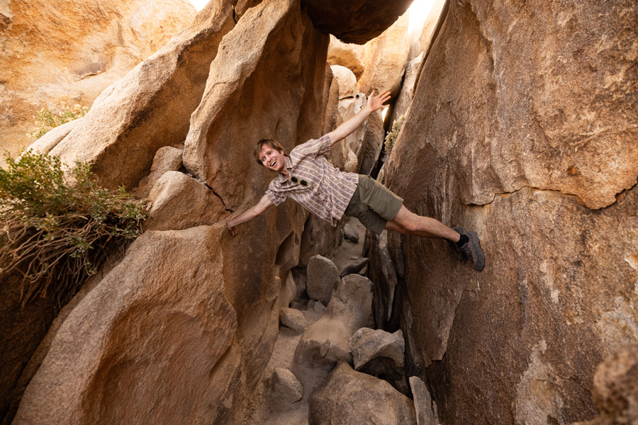 Man balancing on the sides of a cave.