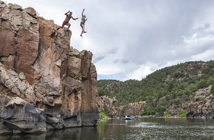 Two people jumping into the river