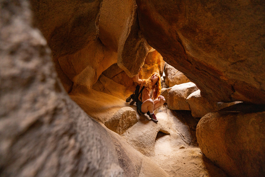 Woman crawling through a cave
