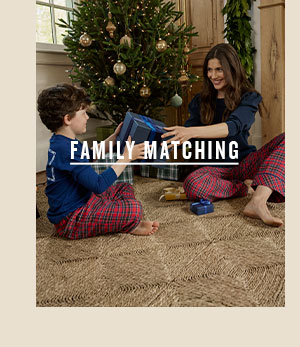 Family Matching. Boy and woman in matching pajamas exchanging gifts.