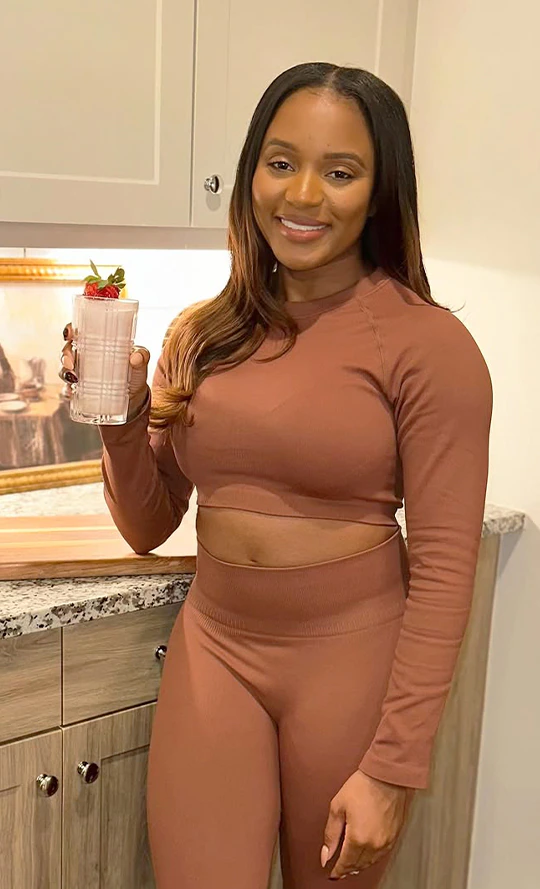 A women with Strawberry-flavored plnt Core Cleanser drink