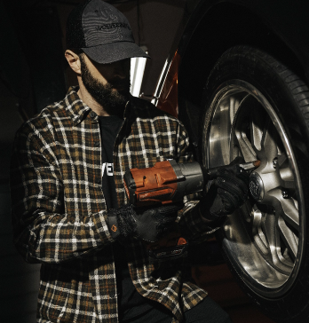 Man using a power tool on a car tire