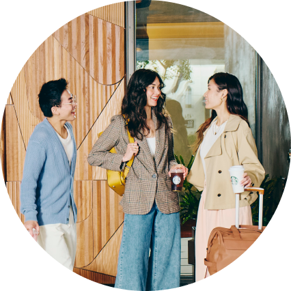 Three travelers meet up in a Marriott hotel lobby, one holding a Starbucks coffee.
