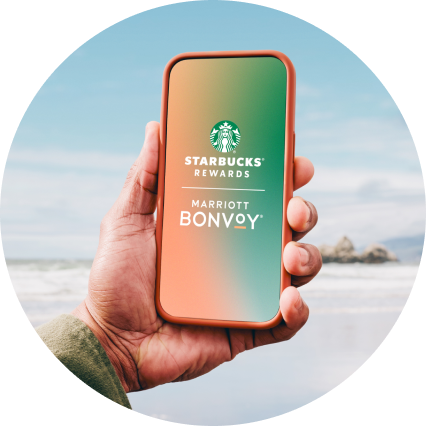 A mobile device with Starbucks Rewards and Marriott Bonvoy logos on the screen.