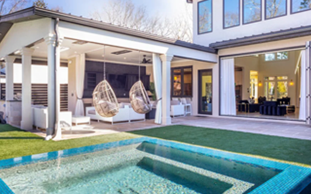 Stylish two-story house with a small pool, hanging chairs, and wide sliding doors opening to a patio area.