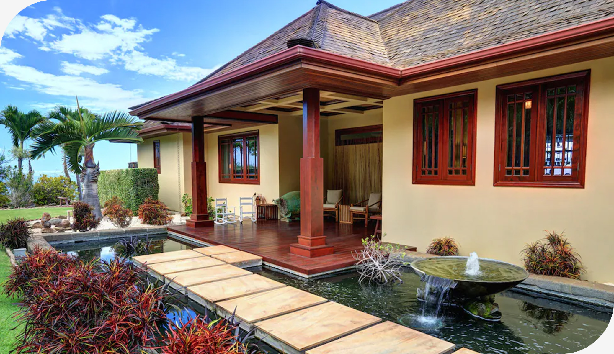 Warm island home with wood details, lush greenery, and a sunlit patio in Maui.