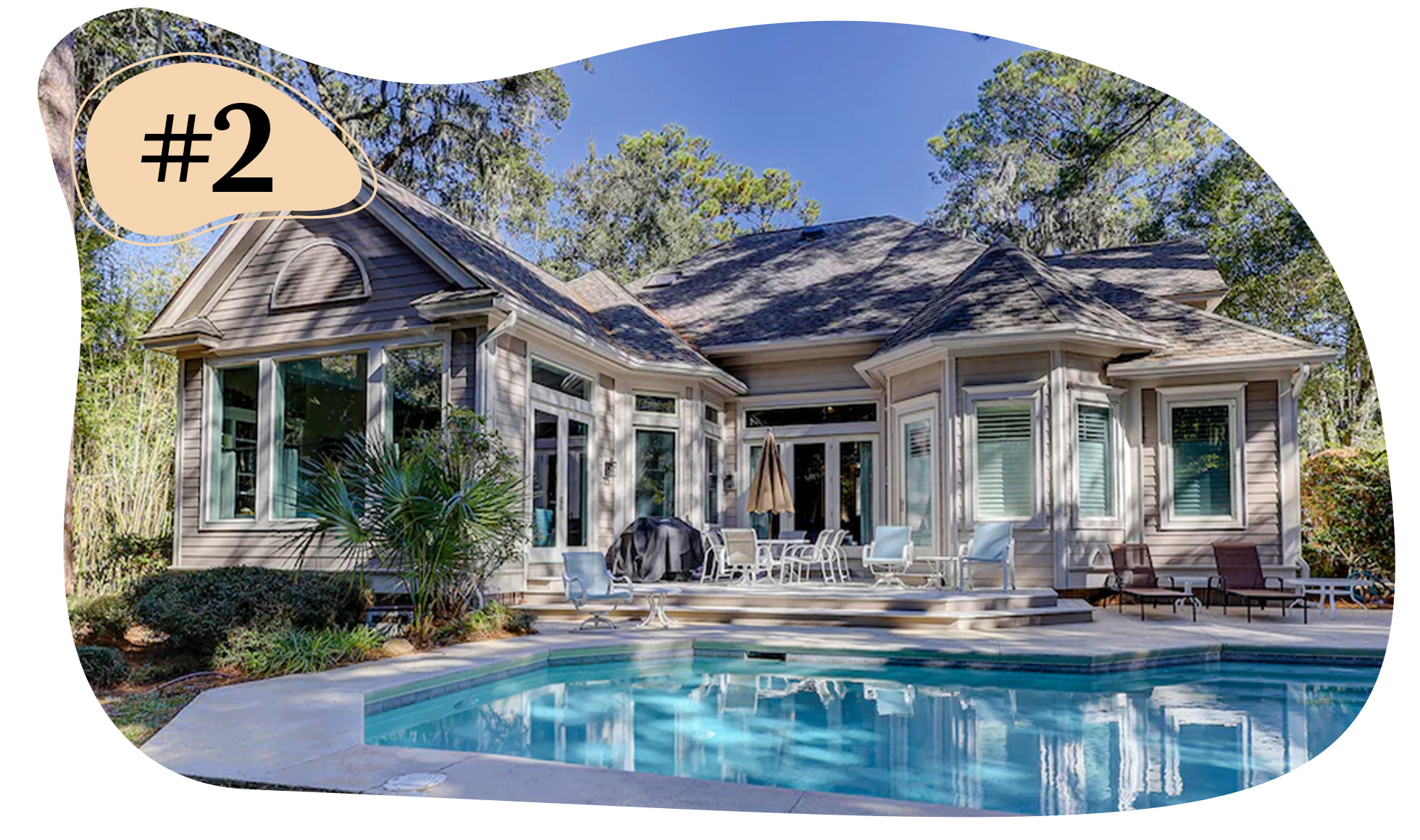 Single-story home with a backyard pool, patio seating, and trees surrounding the outdoor area.