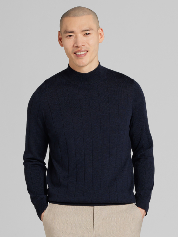 Man wearing navy mock-neck merino sweater.