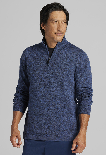 Man wearing a blue quarter-zip sweater, standing against a light background.