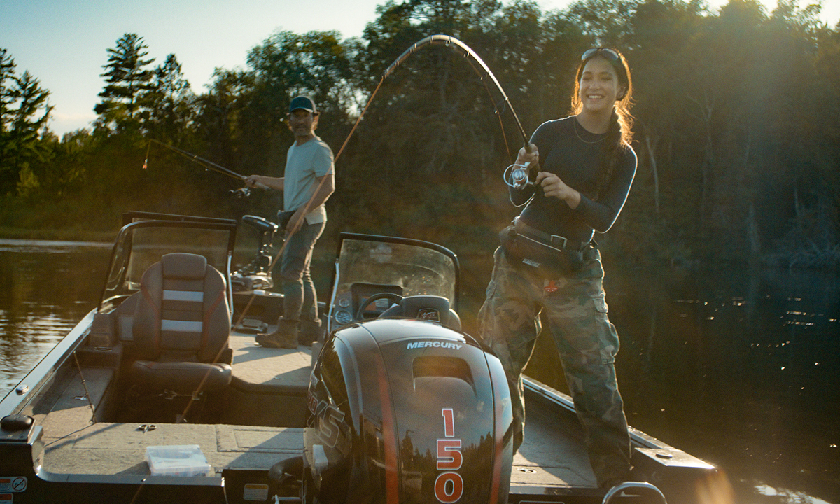 A man and a woman are fishing on a boat with a mercury 150 engine