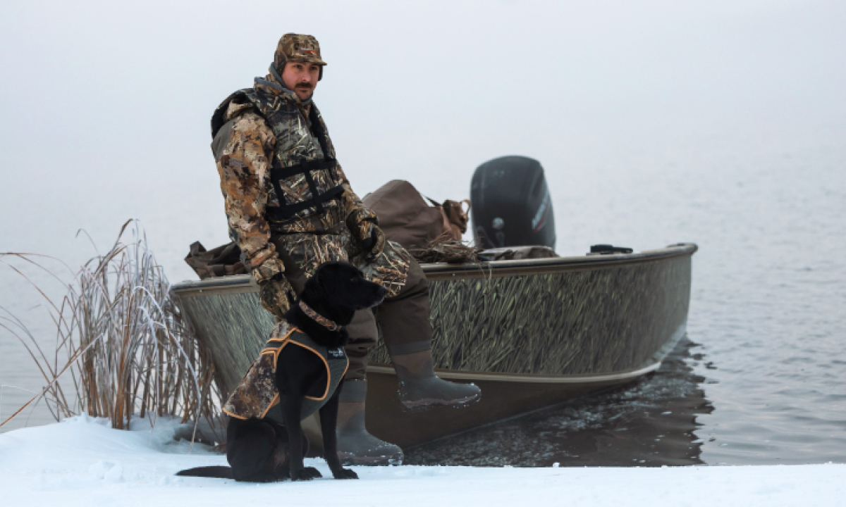 Man with dog on a Lund Alaskan boat with a Mercury 75hp FourStroke Outboard