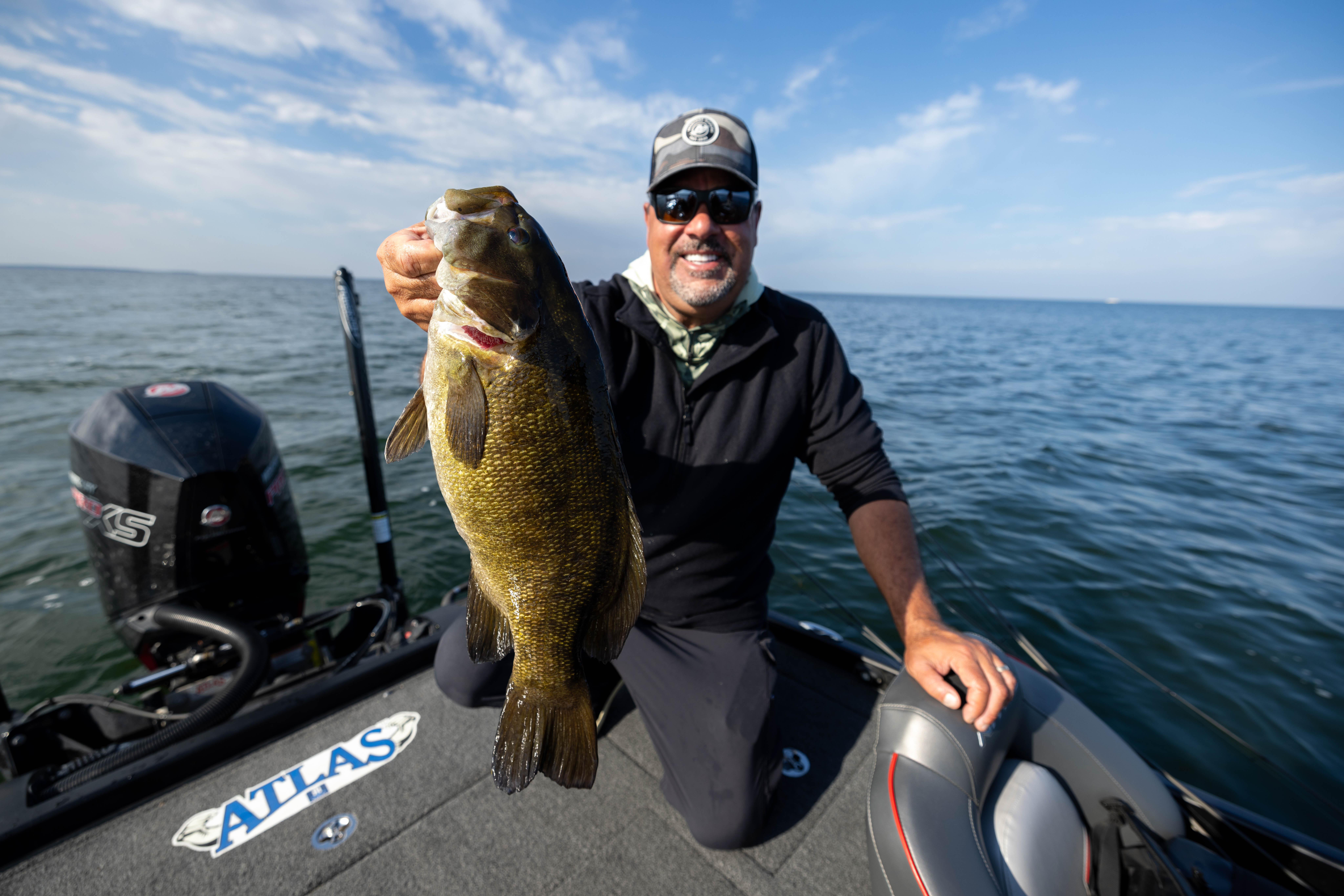 A fisherman holds up a smallmouth bass he just caught.