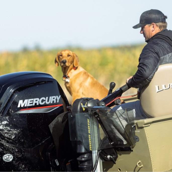 A man and his dog on a boat with a Mercury outboard motor.