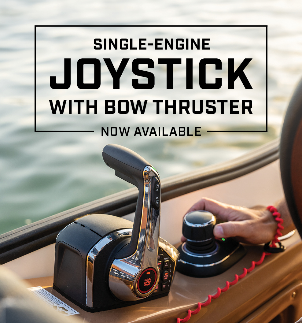 Hand operating a single-engine joystick with bow thruster on a boat.