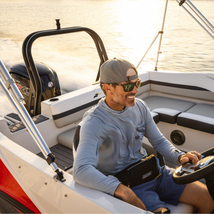 Man on boat smiling in a Mercury Marine Shirt