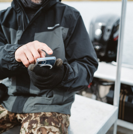 man on a boat using an app on a phone