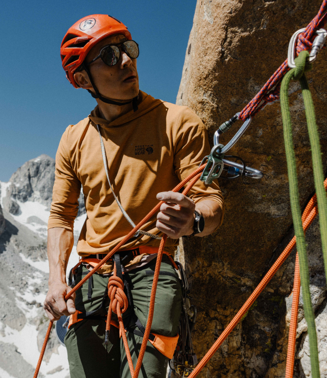 An alpinist wearing the Men's Sunblocker™ Hoody while belaying