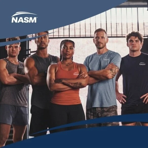 A group of NASM Elite Trainers standing together inside a gym