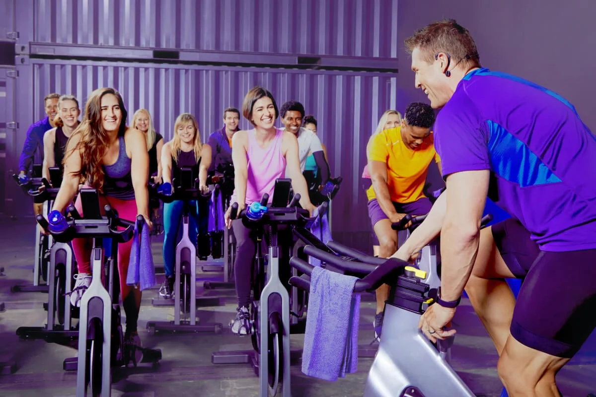 An AFAA/NASM certified indoor cycling instructor leading an indoor biking class
