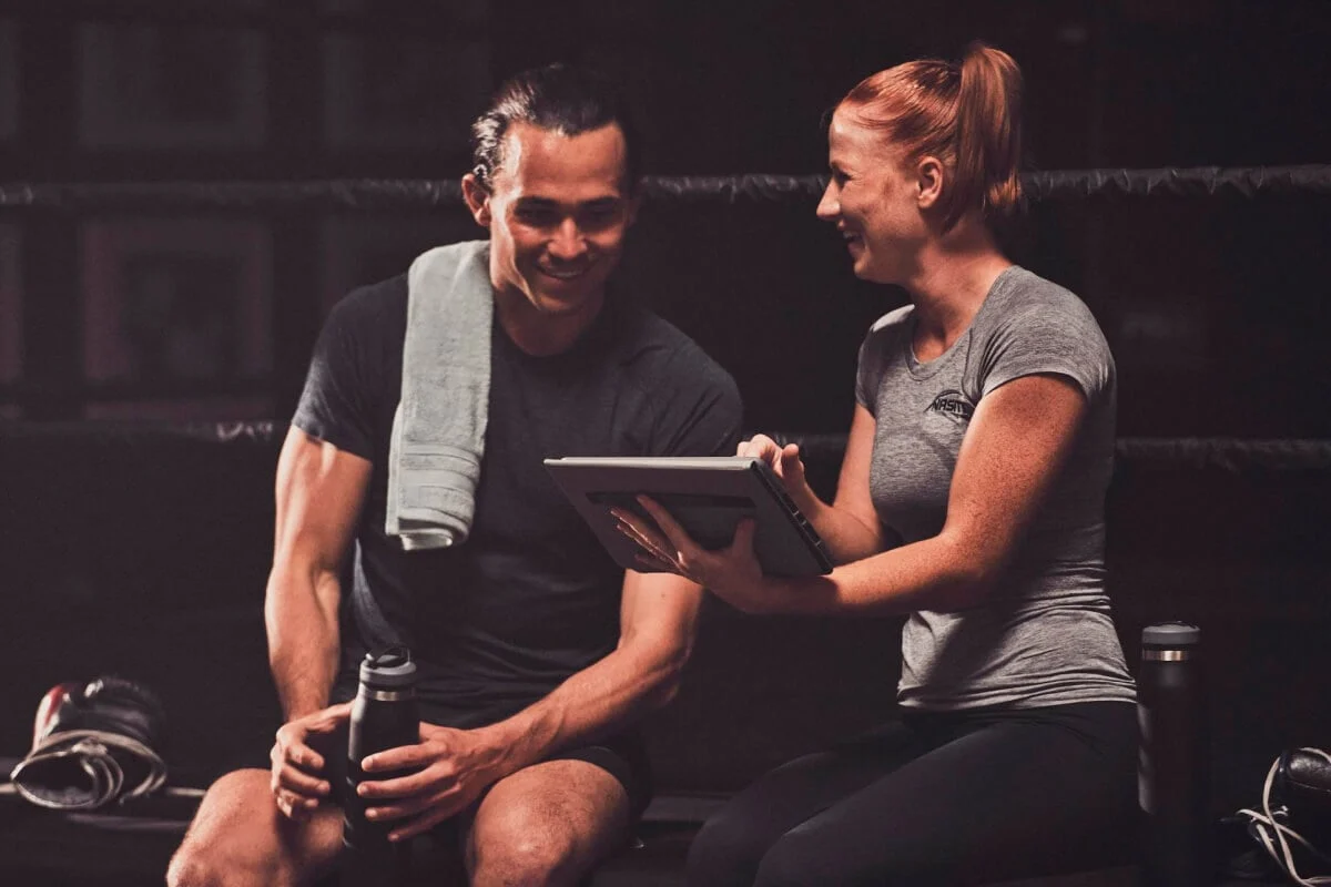Trainer and client reviewing fitness plan on a tablet