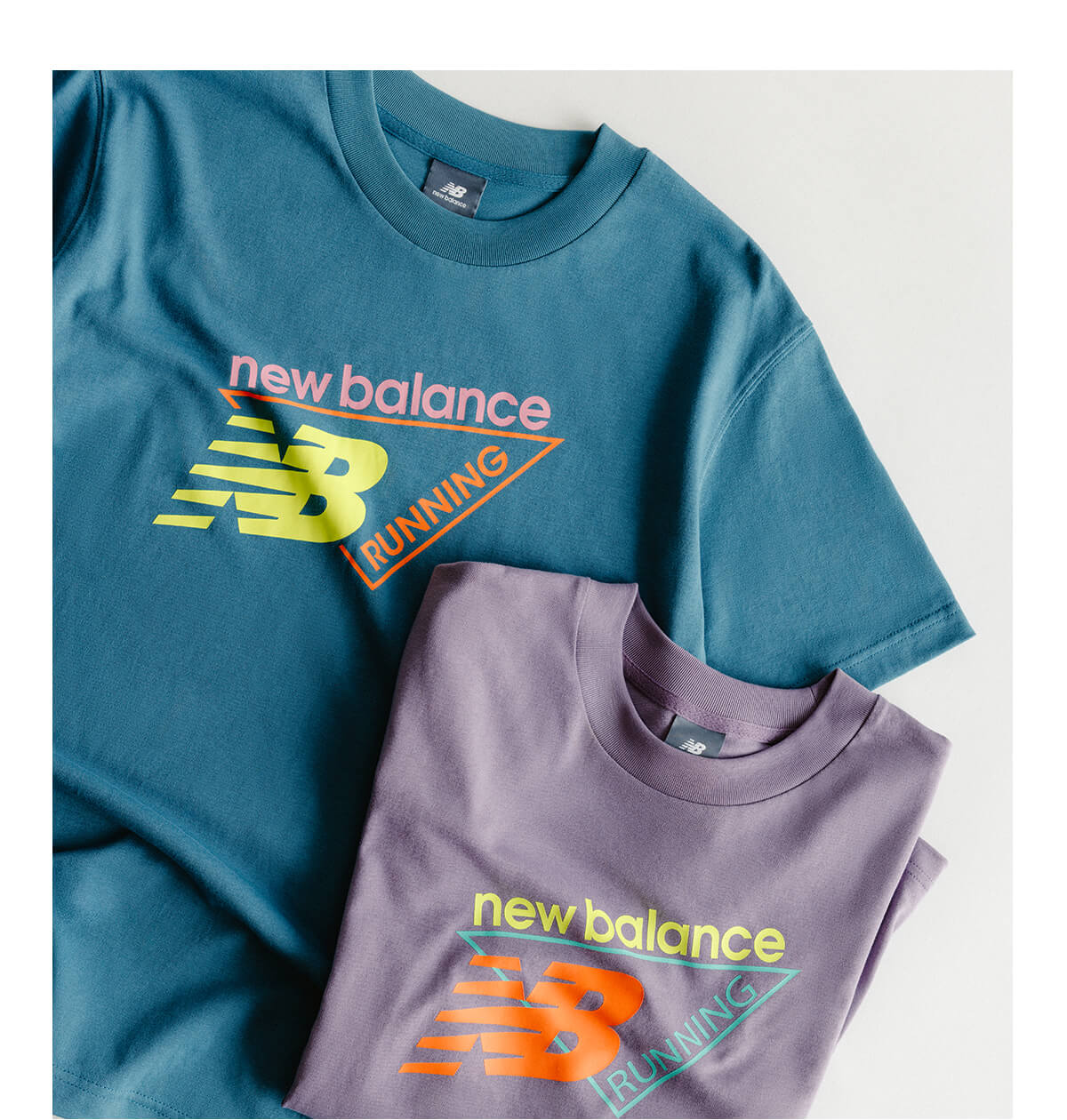 Two New Balance graphic tees laid flat.