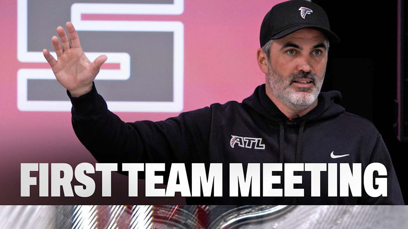 Kevin Stefanski speaks at the first team meeting, raising a hand on stage with “First Team Meeting” text