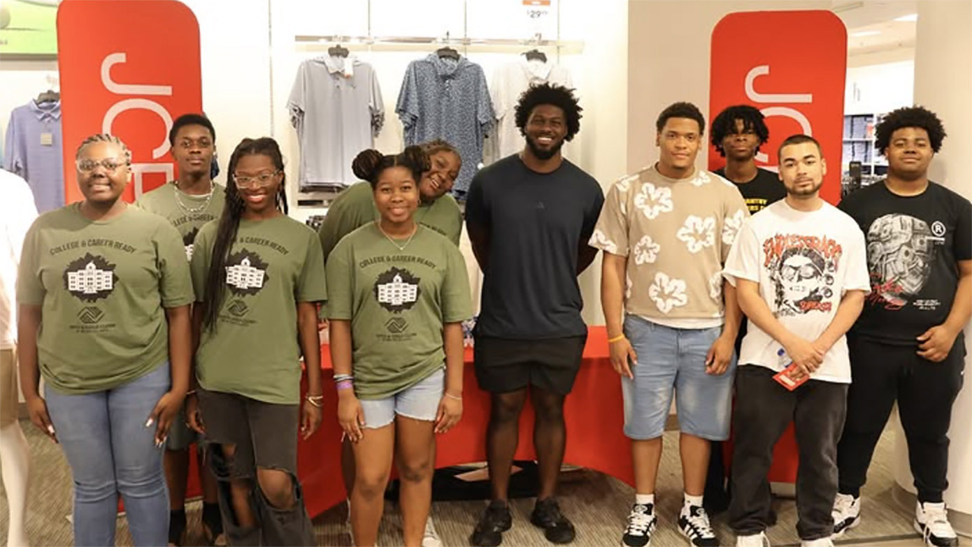 Jalon Walker stands with Boys & Girls Club seniors after gifting graduation outfits
