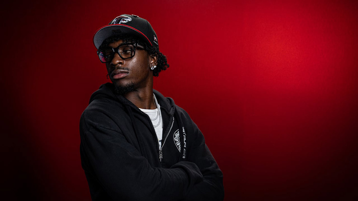 Zachariah Branch posing against a red background in Falcons gear.