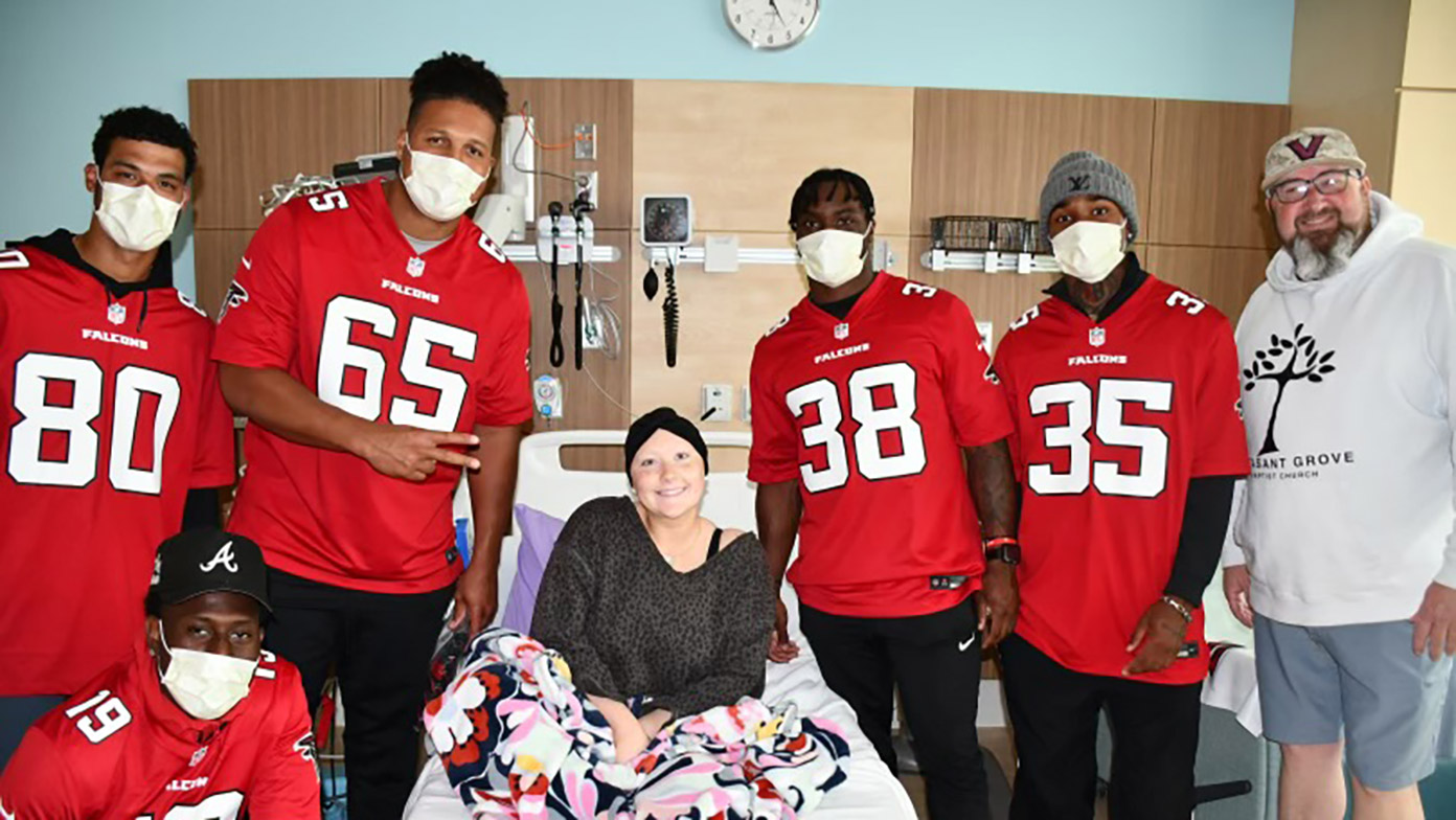 Atlanta Falcons players pose with a patient.