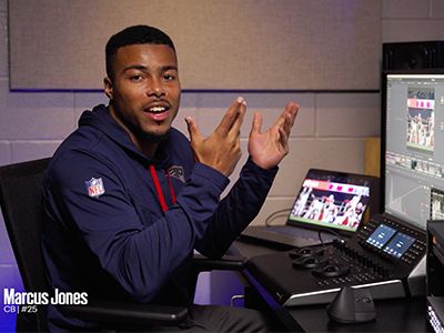 Marcus Jones speaking to the camera while seating at a editing computing desk.