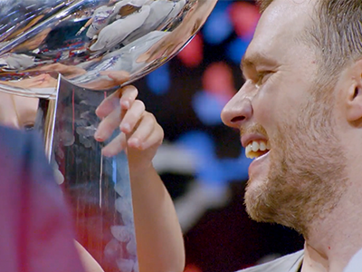 Tom Brady rising one of the Lombardi trophies.