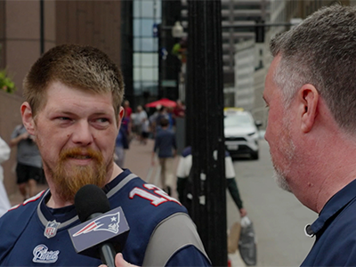 Patriots fan speaking into a microphone.