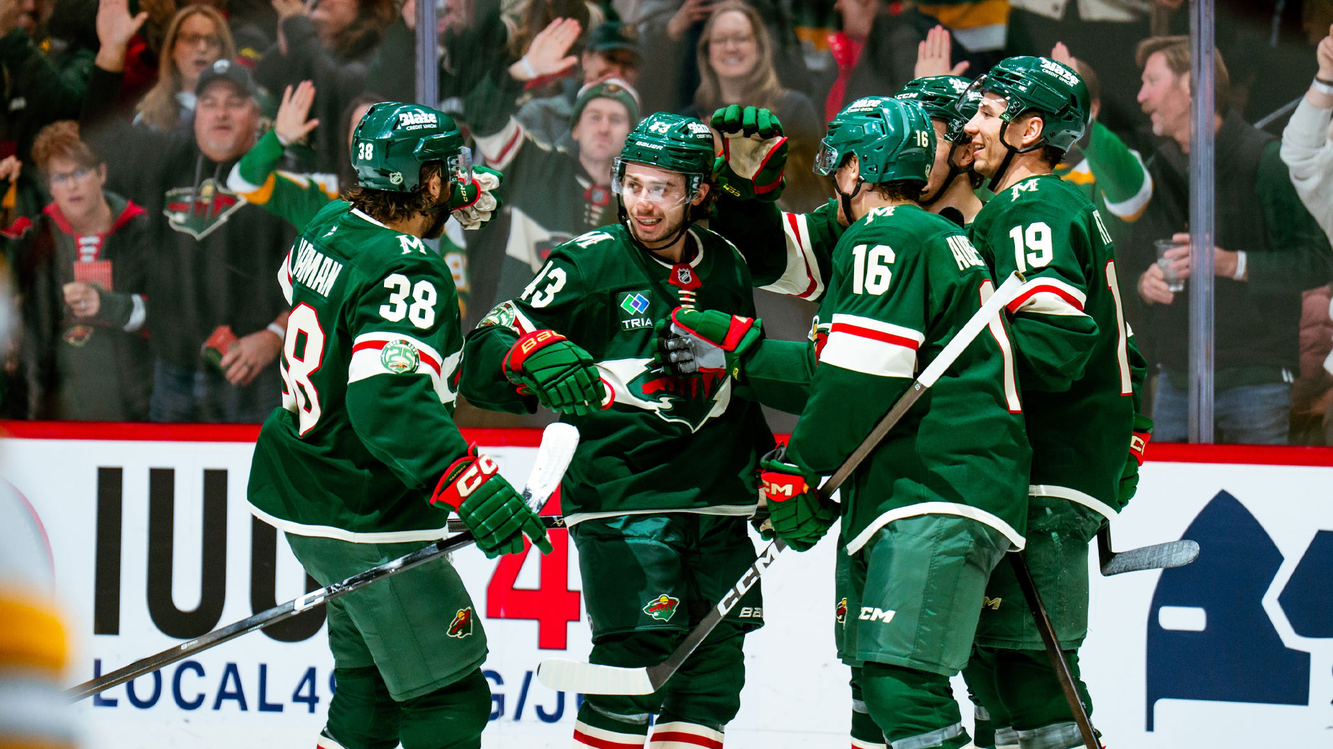 Quinn Hughes celebrates with teammates after first goal with Wild.