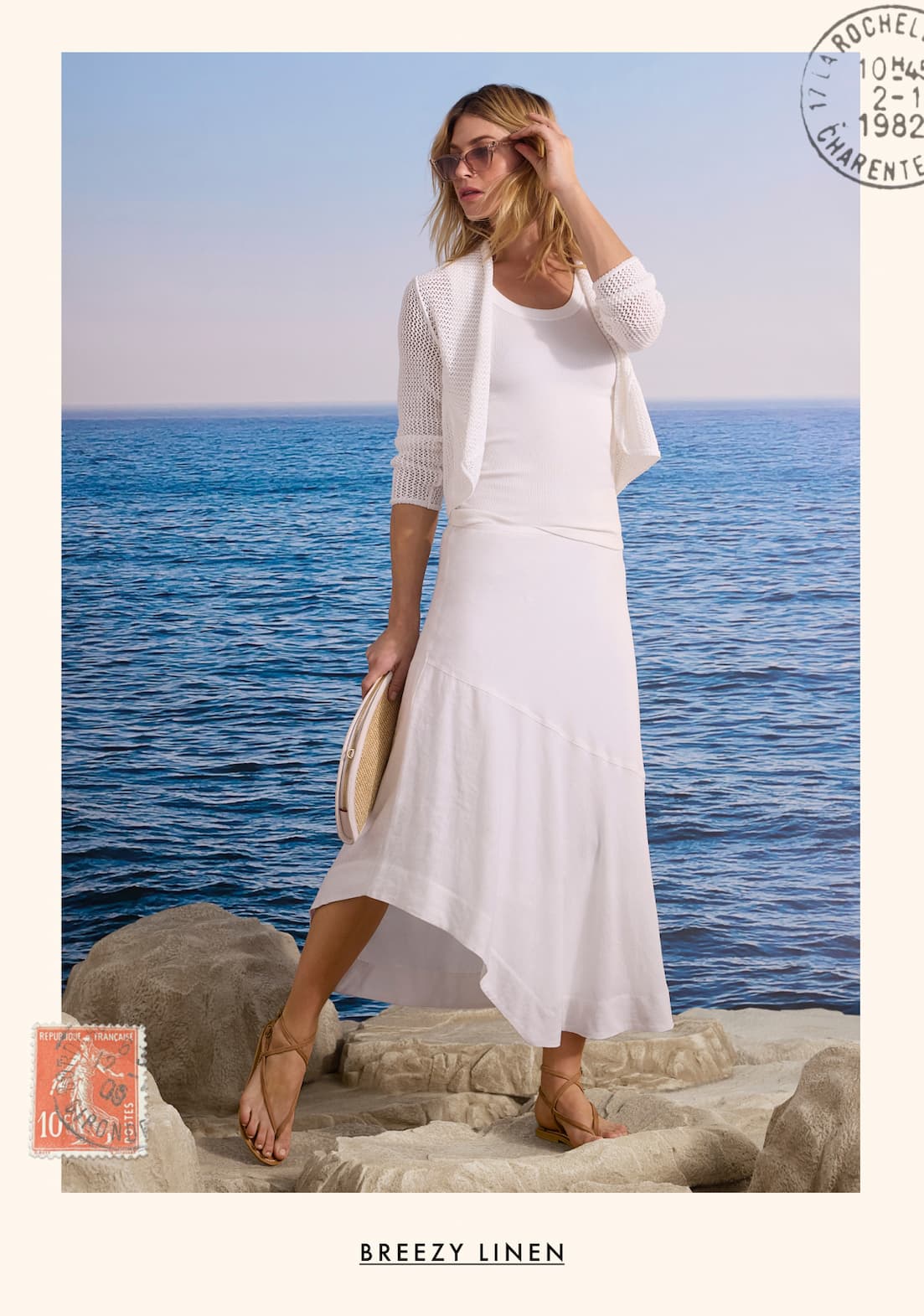 The lady wearing the Mesh Cocoon Cardigan and the Long Engagement Rumba Linen Skirt. She is standing on the rock. Shop Breezy Linen.