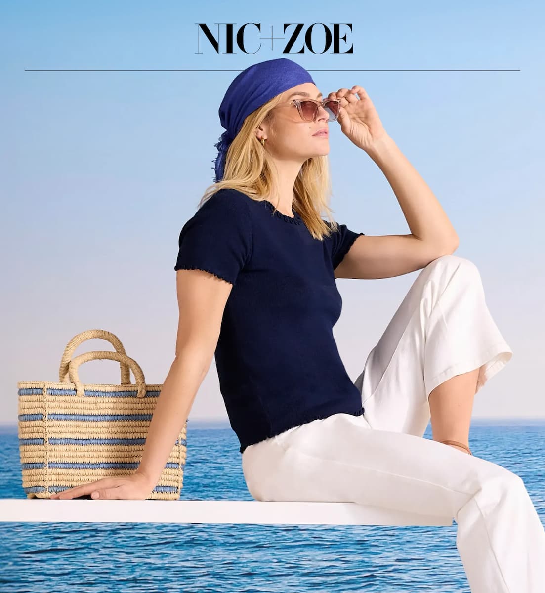 The lady wearing the Ruffle Trim Sweater Tee and the Highland Wide Leg Soft Stretch Belted Ankle Pant. Sitting on the deck.
