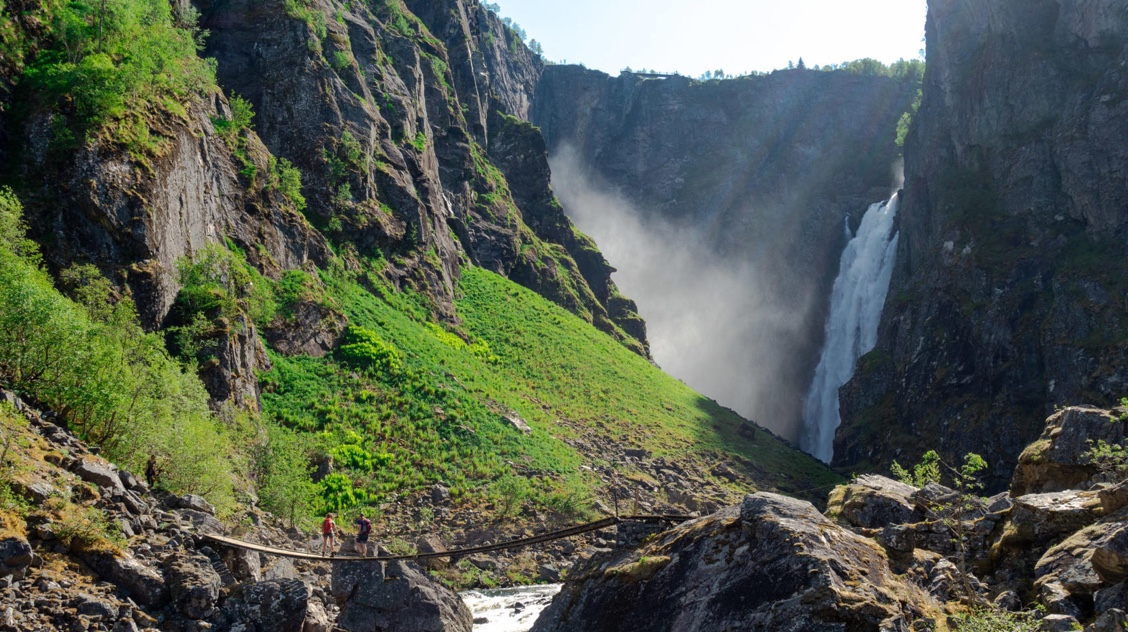People hiking by waterfall