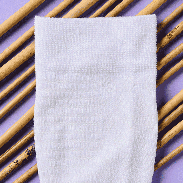 A gif of bamboo compression socks in white, grey, and blue laying on bamboo. Shop bamboo compression socks in pink.   