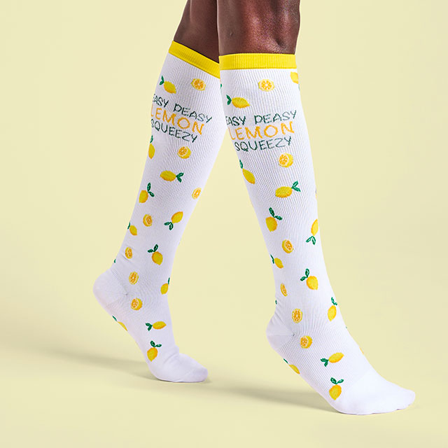 A woman wearing the lemon squeezy compression socks in yellow. Shop women's compression socks.