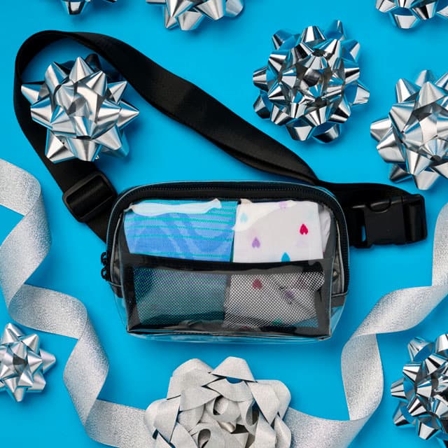 The Compression Socks with Clear Stadium Pack in Blue/White on a blue background with silver bows around. Shop gifts under $50.