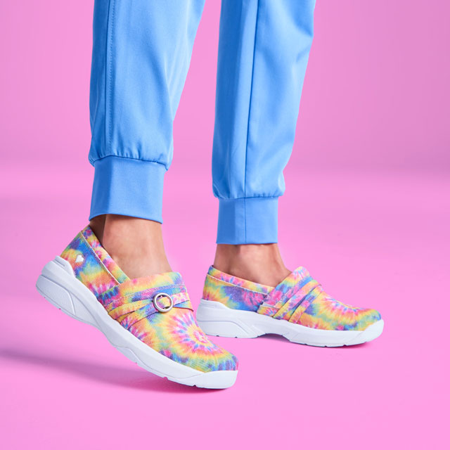 A woman wearing the Ceri slip ons in tie dye. Shop women's.
