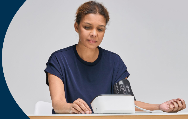 Woman Measuring Blood Pressure at Table
