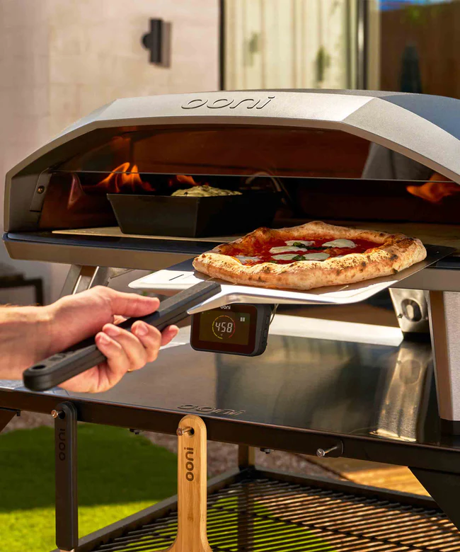 A person cooking a Detroit pizza and a Neapolitan pizza side by side