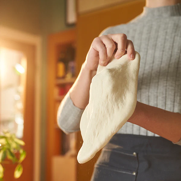 A dough ball being stretched