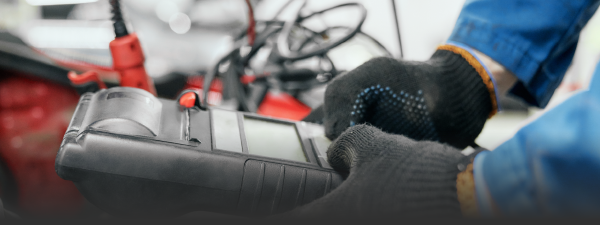 lifestyle image of a mechanic using a battery tester