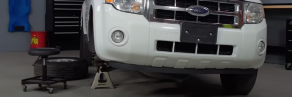 Vehicle with wheel removed propped up with a car jack
