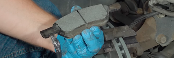 Holding new brake pad in hand