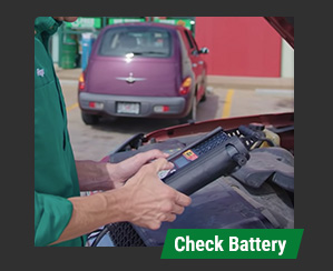 O'Reilly team member testing a battery under the hood 